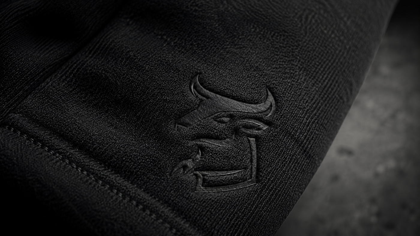 Embossed tonal bull mark on black heavyweight knit, stitch detail visible